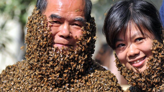 Ein Mann und eine Frau haben Körper und Kopf voller Bienen