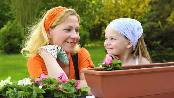Mutter und Tochter, freudig bei der Gartenarbeit