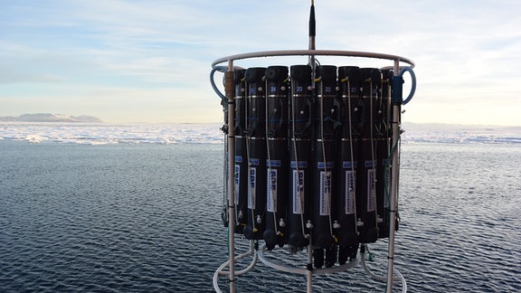 Apparatur zur Probenentnahme über Ozeanwasser, im Hintergrund Packeis und Gletscher