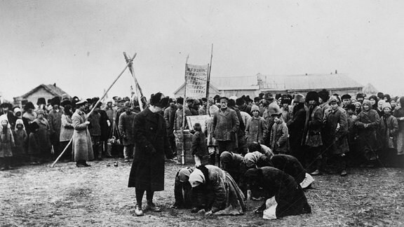 Hungernde Russinnen knien vor einem Mitarbeiter der American Relief Administration