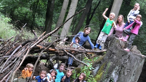 Kinder spielen bei einem Ferienprojekt Jäger und Sammler.