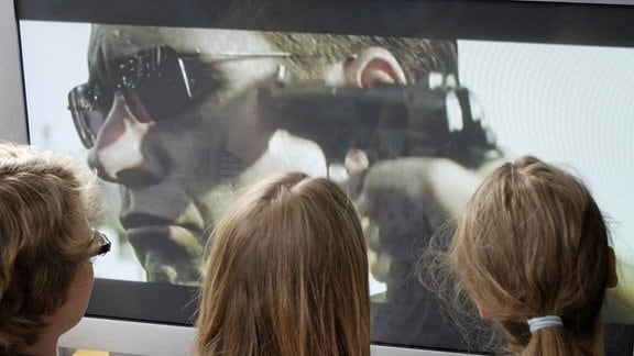 Symbolbild: Kiner sehen einen Gewaltfilm im Fernsehen .