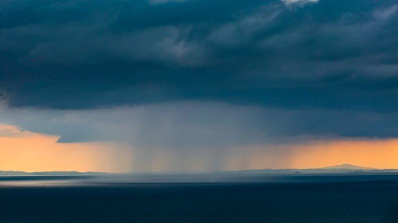 Graue Regenwolken über Ozean