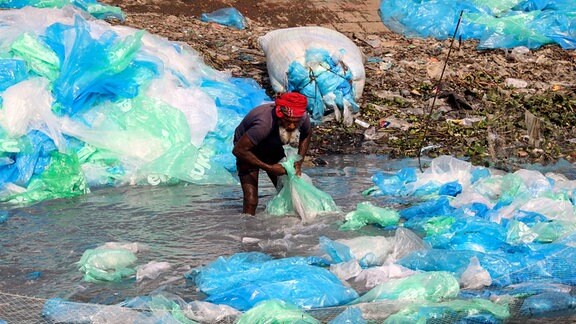Arbeiter trocknen gebrauchte Plastiktüten.
