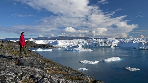 Tourist mit Blick auf den Kangia Eisfjord, Diskobucht, UNESCO Welterbe, Westgrönland