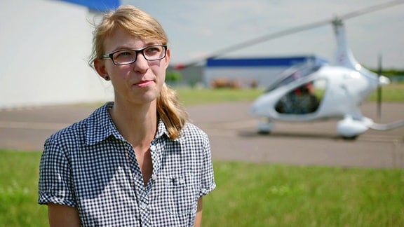 Junge Frau vor einem Gyrocopter 