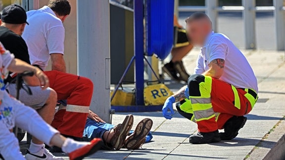 Notfallsanitätern der Feuerwehr bei einer hilflosen Person in großer Hitze