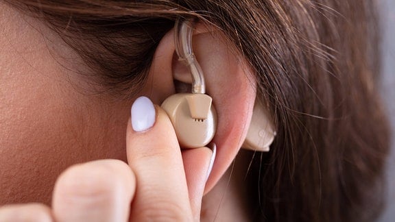 Ohr einer jungen Frau mit Hörgerät