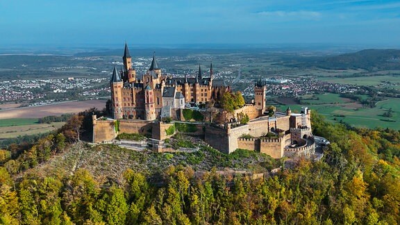Luftdrohnenaufnahme der mittelalterlichen Burg Hohenzollern auf einem Hügel im Herbst, Baden-Württemberg