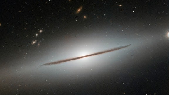 Die rund 100 Millionen Lichtjahre entfernte Galaxie NGC 1032 ist eine Spiralgalaxie. Von der Erde aus sieht man sie allerdings lediglich von ihrer Seite, eine Schicht aus Gas und Staub bildet den dunklen Rand.