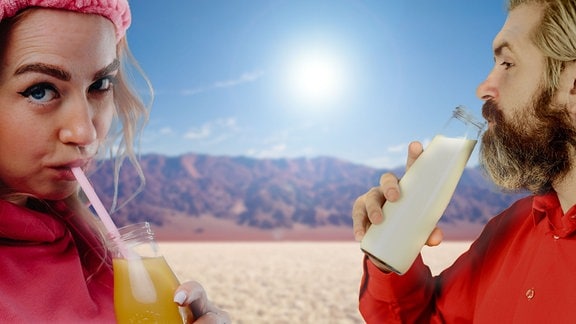 Fotomontage: Frau mit weicher rosafarbener Schleife und rosafarbenen Oberteilt schaut keck in Kamera, während sie O-Saft mit Strohhalm aus Flasche trinkt. Mann mit Bart und rotem Hemd daneben im Profil trink Milch aus Glasflasche. Hintergrund: Death-Valley-artige, KI-generierte Wüstenlandschaft mit gleißender Sonne