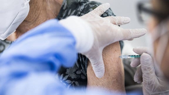 Eine aeltere Person bekommt eine Impfung gegen Corona im Impfzentrum in Schoenefeld,