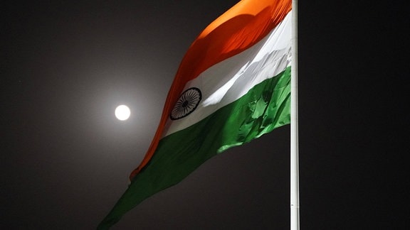 Flagge von Indien weht vor Nachthimmel mit kleinem hellen Mond