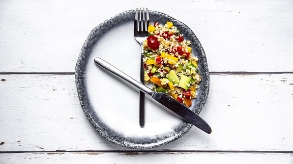 Symbolfoto, Essen auf einem Teller der gleichzeitig mit Messer und Gabel eine Uhr darstellt