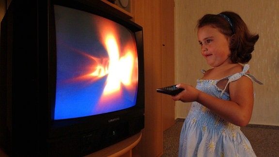 Kleines Mädchen schaltet den Fernseher aus