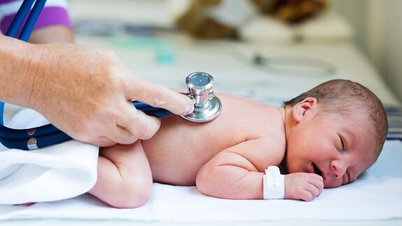 Ein Baby wird mit einem Stethoskop abgehört