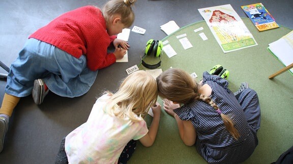 Kinder lernen zusammen bei einer Gruppenarbeit auf Bodenmatten