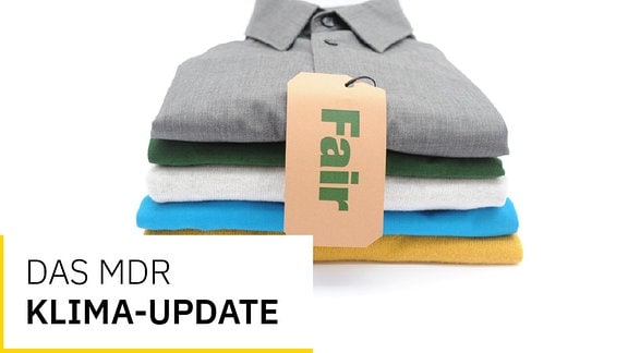 Stapel von verschiedenfarbiger Oberbekleidung mit natürlich-braunem Label-Schild und grüner Aufschrift "Fair". Text "Das MDR Klima-Update"