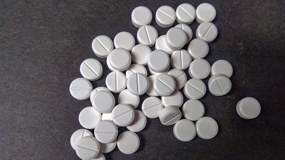 Runde, weiße Kortison-Tabletten, auf einen Tisch geschüttet