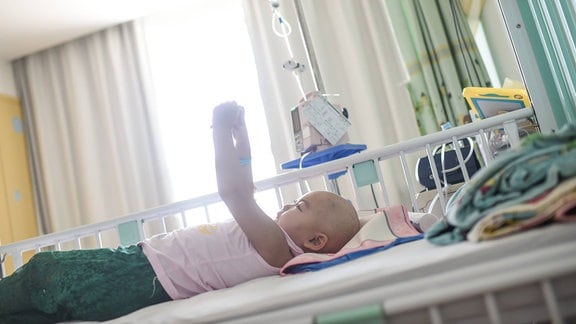 Krebskrankes Kind liegt in einem Krankenhausbett.