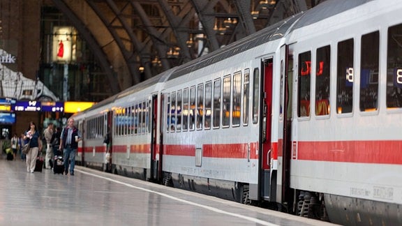 Inter-City Fernreisezug mit weißer Lackierung und rotem Streifen, klassische Eisenbahnwagen, Flucht nach hinten, Halle in Leipzig Hauptbahnhof