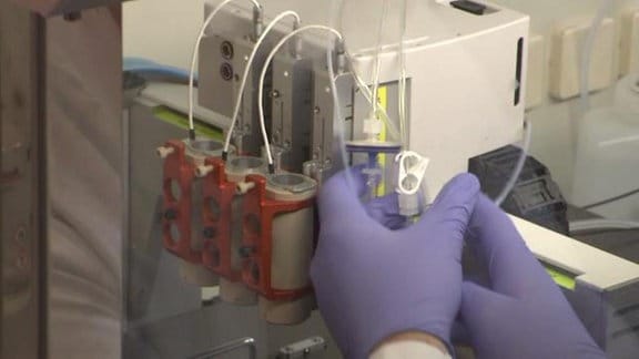 Ein Wissenschaftler befüllt den Drucker mit einer "Biotinte", in der sich lebende Zellen befinden.