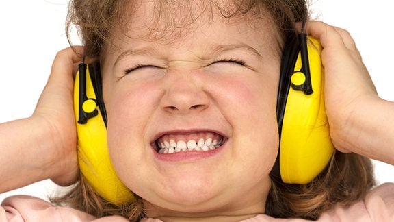 Ein Mädchen trägt Gehörschutz um sich vor Lärm zu schützen
