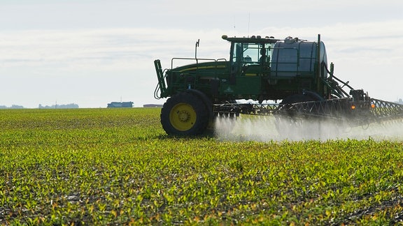 Traktor versprüht Herbizid auf Feld in Manitoba, Canada.