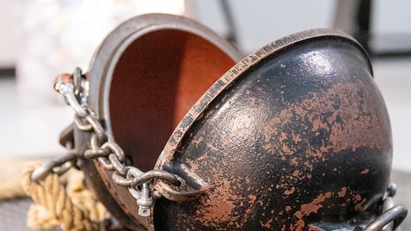 Zwei aufeinanderpassende  Halbkugel aus Kupfer, an denen jeweils ein Seil befestigt ist.