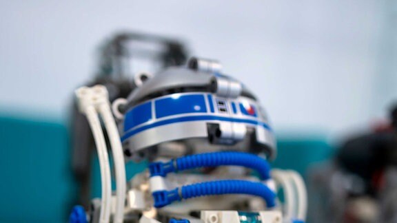 Ein kleiner Roboter aus Lego, der stark an einen Androiden aus den Star Wars Filmen erinnert.