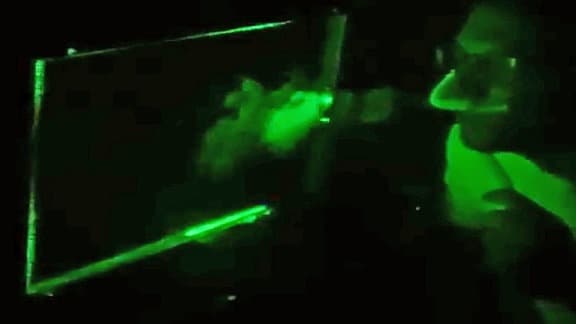 Eine Testperson hustet in einen Laserscanner