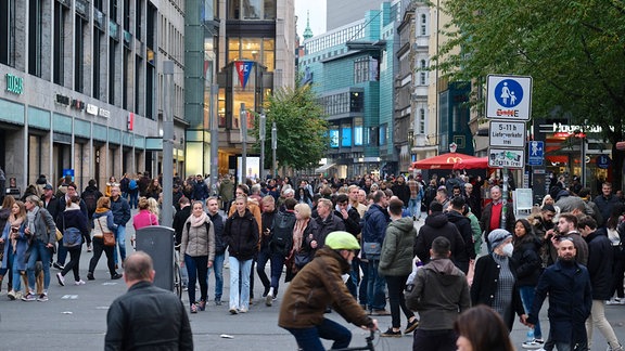Typische Einkaufsstraße, Fußgängerzone mit sehr vielen Menschen, dichter Bebauung links und rechts, Geschäfte 