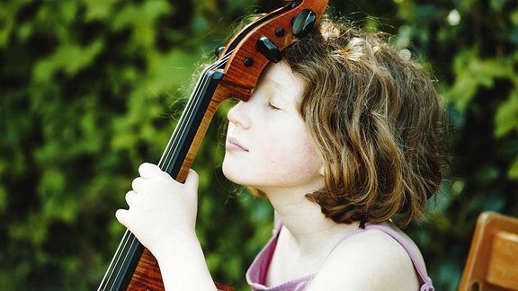 Ein Mädchen, das eine Pause mit ihrem Cellos macht.