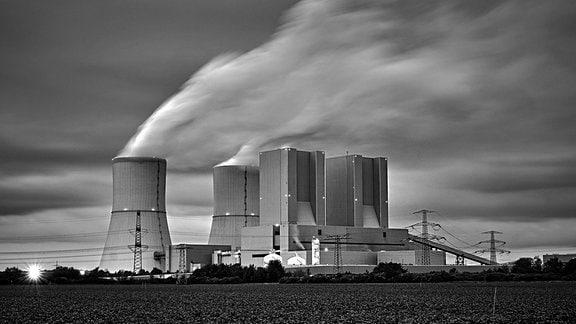 Schwarz-weiß-Bild bon Kohlekraftwerk Lippendorf mit hohen Kühltürmen mit aufsteigendem Dampf, Vordergrund Feld