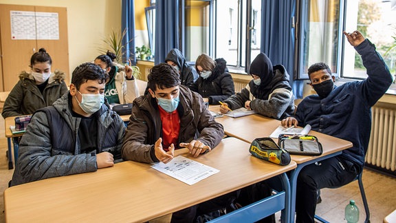 Schüler an der Globus Gesamtschule am Dellplatz sitzen in ihren dicken Winerjacken bei offenem Fenster in ihrem Klassenraum