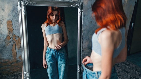 Schlanke Frau vor einem Spiegel