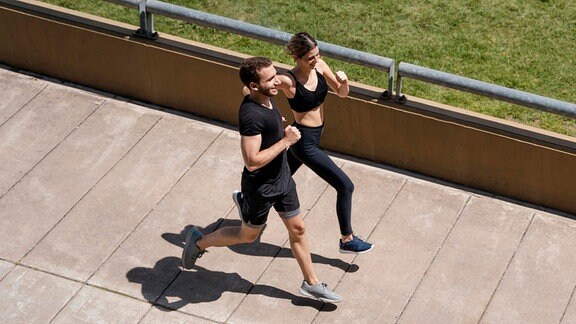 Ein Mann und eine Frau joggen nebeneinander.