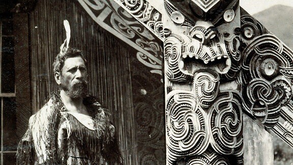 Maori in Wairoa vor Totempfahl um 1880
