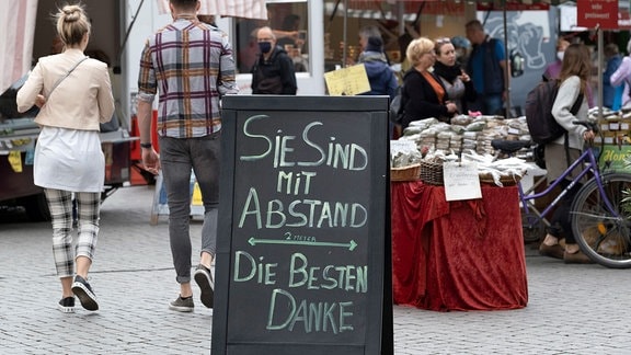 Hinweisschild zum Abstandhalten auf dem Wochenmarkt auf dem Richard-Wagner-Platz in Leipzig.