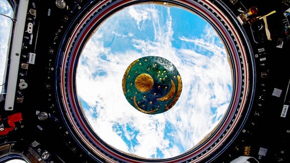 Eine Kopie der Himmelsscheibe von Nebra schwebt auf der Internationalen Raumstation ISS. Sie befindet sich in der Cupola, dem Weltraumfenster, von dem aus man die Erde im Hintergrund erkennen kann. Der deutsche Esa-Astronaut Matthias Maurer hatte sie mit auf die Raumstation genommen.