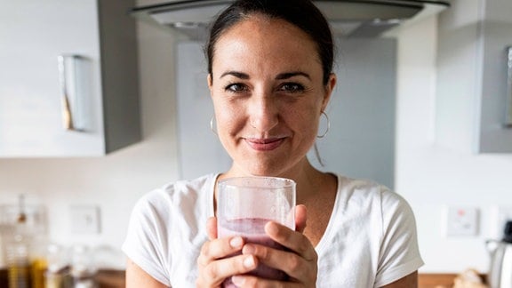 Frau hält Glas mit Milchshake