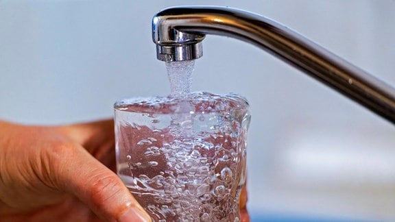 Trinkwasser läuft aus dem Wasserhahn in ein Glas