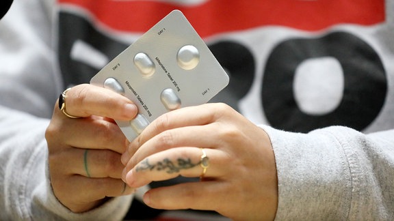 Ein Tablettentableau wird in einer Hand gehalten.