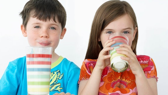 Zwei Kinder trinken ein Glas Milch