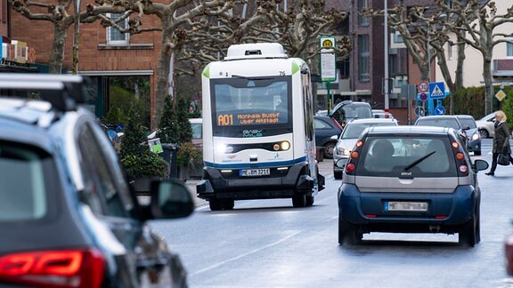Autonom fahrender Linienbus bewegt sich im Stadtverkehr zwischen anderen Autos in Monheim am Rhein.