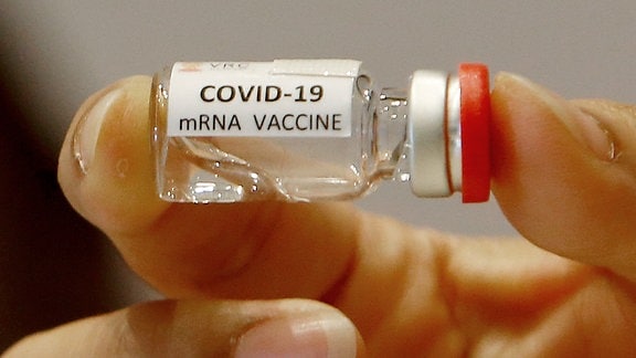 Eine Hand hält einen mRNA Impfstoff