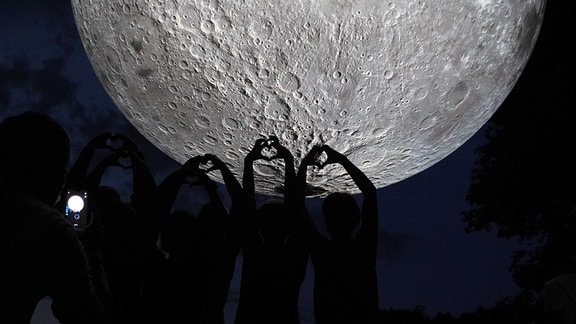 Hände formen Herzen - vor dem Mond.