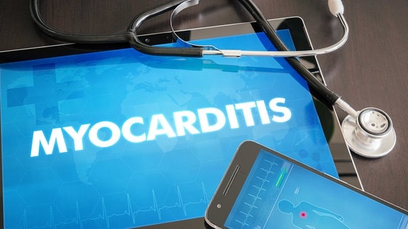 Auf einem Tablet steht der Begriff Myokarditis. Daneben liegt ein Handy mit einer Grafik eines menschlichen Körpers und ein Stetoskop.