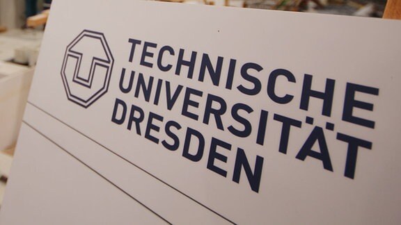Ein Schild mit Technische Universität Dresden in der Fakultät Bauingenieurwesen / Professur für Wasserbau.