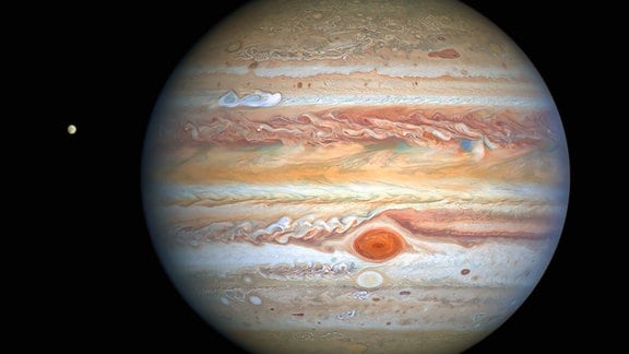Dieses neueste Bild von Jupiter, das am 25. August 2020 vom Hubble-Weltraumteleskop der NASA / ESA aufgenommen wurde, wurde aufgenommen, als sich der Planet 653 Millionen Kilometer von der Erde entfernt befand. Hubbles scharfe Sicht gibt Forschern einen aktualisierten Wetterbericht über die turbulente Atmosphäre des Monsterplaneten, einschließlich eines bemerkenswerten neuen Sturms und eines Cousins ​​des Großen Roten Flecks, der erneut die Farbe wechselt. Das neue Bild zeigt auch Jupiters eisigen Mond Europa. 